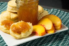 a plate with biscuits, jam and peaches on it