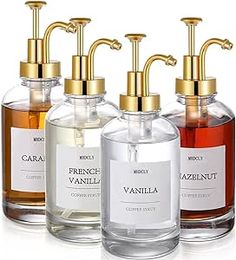 four different types of soap dispensers in glass bottles with gold faucets