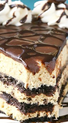 a piece of cake with chocolate frosting and white icing on top is sitting on a plate