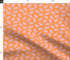 an orange fabric with white and pink paisley designs on it, as well as a ruler