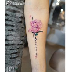 a pink rose tattoo on the left inner forearm and lower arm with words written in cursive writing