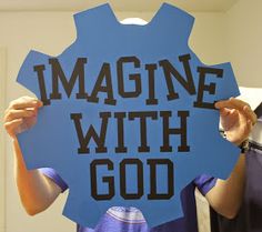 a man holding up a sign that says imagine with god