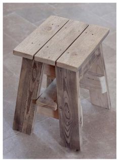 a wooden stool sitting on top of a tile floor