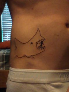 a person with a small tattoo on their stomach that looks like a dog and fish