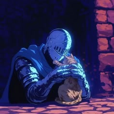 a man in a blue suit sitting on the ground with his head down and hands over his face