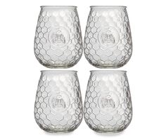 four clear glass tumblers are lined up in a row