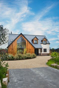 a large house with a driveway leading up to it and lots of greenery on the other side