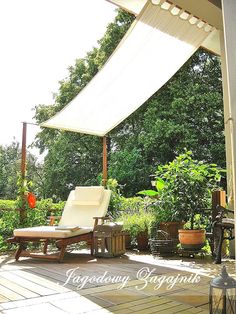 an outdoor patio with chairs and tables under a white awning over the deck area