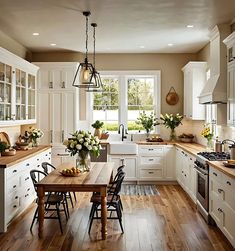 a kitchen filled with lots of white cabinets and counter top next to a wooden table