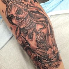 a woman's arm with a skull and flowers on it