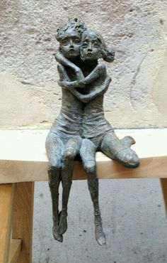 a statue of two people sitting on top of each other