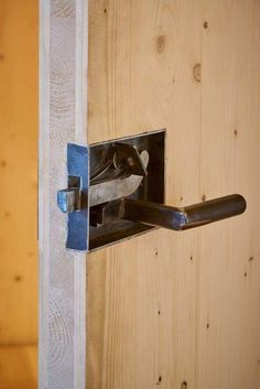 a close up of a door handle on a wood paneled wall with a metal latch