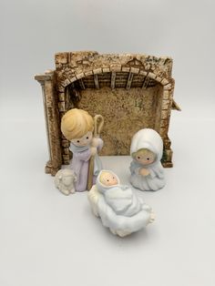 three figurines are sitting in front of a fire place with a manger scene