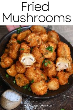 fried mushrooms in a black bowl with parsley on the side and text overlay