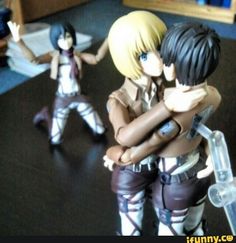 two figurines that are sitting on a table with one being hugged by the other