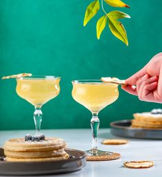 a person dipping some food into two glasses