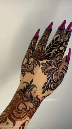 a woman's hand with henna tattoos on it