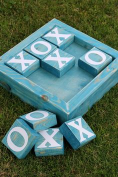 a blue box with white letters on it sitting in the grass next to some blocks