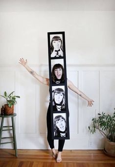 a woman standing in front of a mirror with pictures on it's face and arms