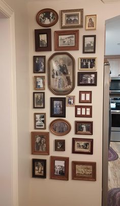 a wall with many framed pictures on it