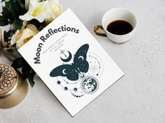 a book sitting on top of a table next to a cup of coffee and flowers