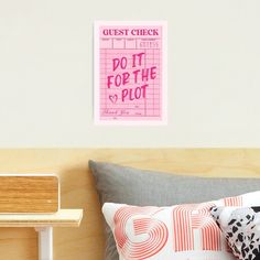 a pink poster on the wall above a bed in a room with wood headboard