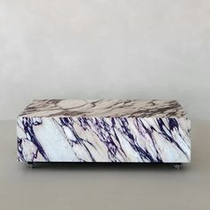 a white and purple marble box sitting on top of a table