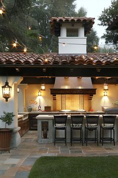 an outdoor kitchen is lit up with lights