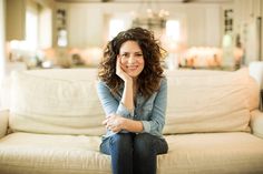 a woman sitting on top of a white couch