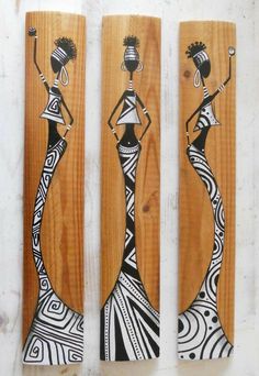 three wooden wall hangings with designs on them