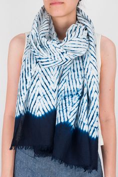 a woman wearing a blue and white tie dye scarf with fringes on the ends