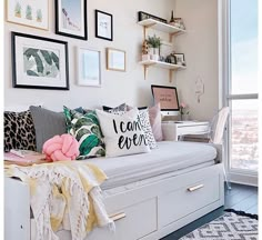 a living room filled with lots of furniture and pictures on the wall above it's bed