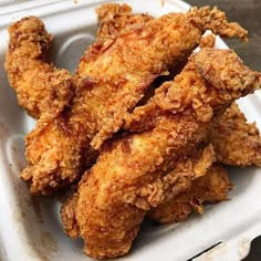 fried chicken sticks in a white container on a table