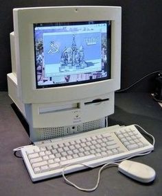 an old desktop computer sitting on top of a desk next to a keyboard and mouse