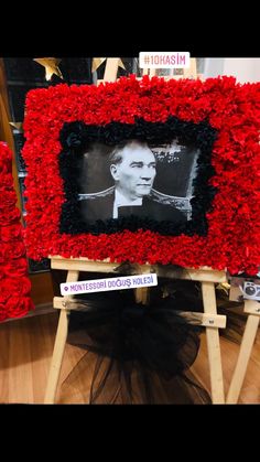 a photo frame made out of red flowers with a black and white image on it