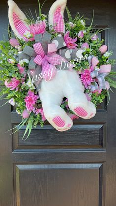 a white stuffed animal sitting on top of a wooden door handle covered in pink flowers