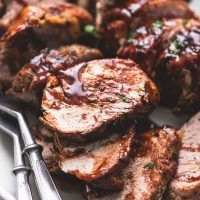 some meat is sitting on a plate with tongs