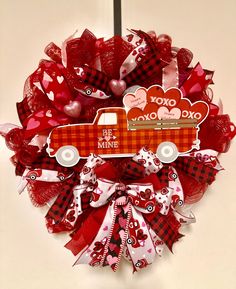 a wreath with a red truck and hearts on it