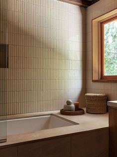 a bath room with a sink and a tub next to a window in the corner