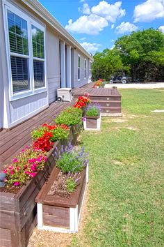 several flower boxes are lined up on the side of a home's front porch