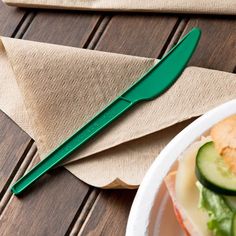 a sandwich with cucumbers and cheese is on a plate next to a knife