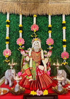 an idol is displayed in front of flowers and decorations