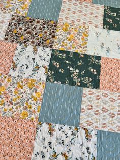 a patchwork quilt with many different colors and patterns on the top, along with small flowers