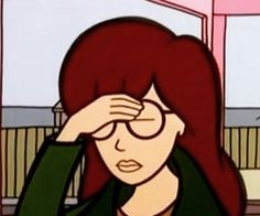 a woman with red hair and glasses holding her hand to her face