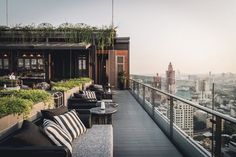 an outdoor patio with black and white striped furniture, overlooking the cityscape in the distance