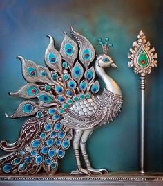 a metal peacock statue next to a lamp on a shelf