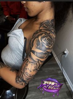 a woman with a rose tattoo on her arm next to a purple bag and clock