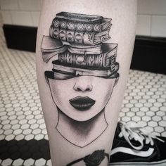 a woman's leg with books stacked on top of her head and an eye