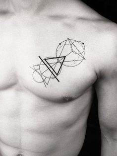 a black and white photo of a man's chest with an abstract tattoo on it