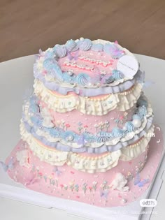 a three tiered cake is decorated with pastel icing and stars on it